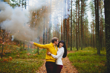 The guy and the girl with the hand flare in forest