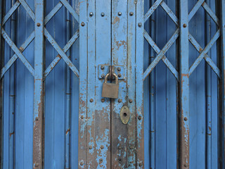 Old rusted lock on blue rusty iron gate