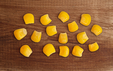 Grains of corn on a wooden table.