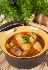 Stewed potatoes in a ceramic pot.