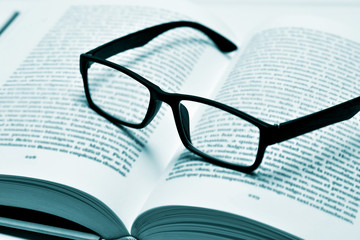 eyeglasses on an open book, in duotone