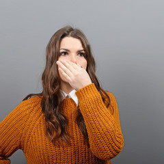 Portrait of woman covering nose with hand showing that something