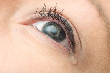 Fototapeta na wymiar Close-up tear on young woman's eye 