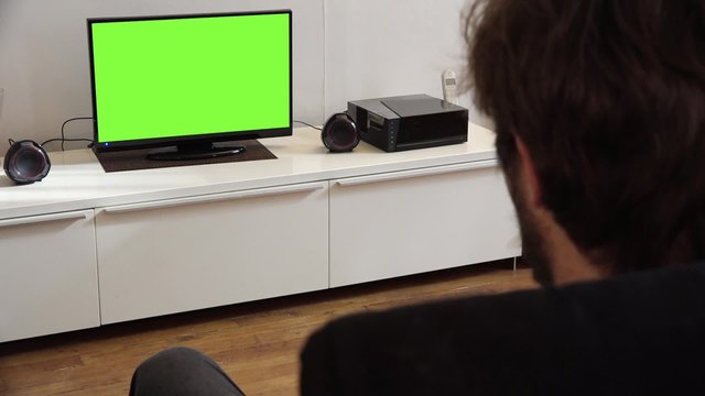 Watching Television Green Screen at Home. Young man watching a television green screen alone at home - 1080p