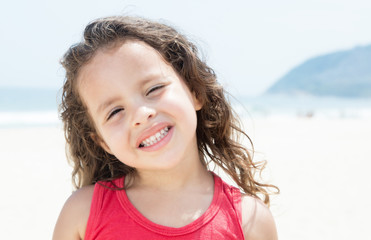 Lachendes Kind im roten Shirt am Strand
