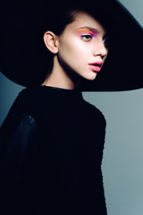 Portrait of beautiful girl in hat in profile, posing in studio