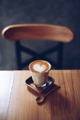 cup of coffee latte art on the wood desk