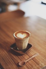cup of coffee latte art on the wood desk