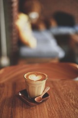 cup of coffee latte art on the wood desk