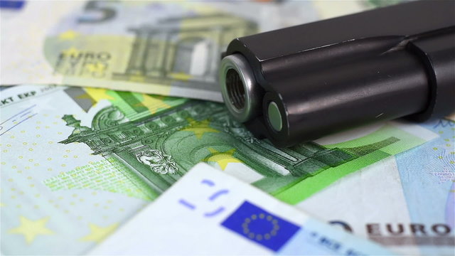 euro bills and black gun, close up