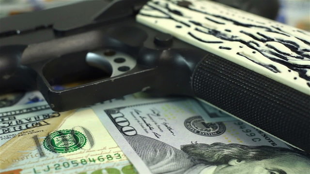 dollar bills and black gun, close up