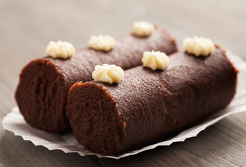 Two brown biscuit cakes on a white decorative paper