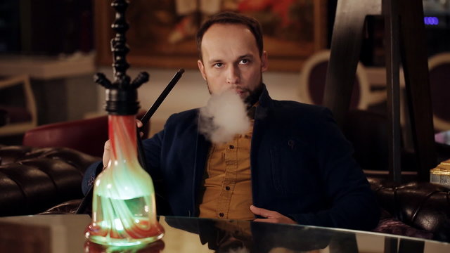 Man smoking a traditional Middle Eastern Hookah.