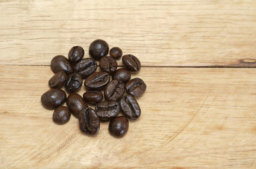 Roasted coffee beans / Roasted coffee beans placed on a wooden floor.