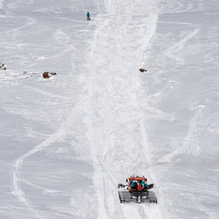 Snowcat with people rises up the hill