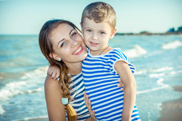 Fototapeta na wymiar Mother and her son having fun on the beach