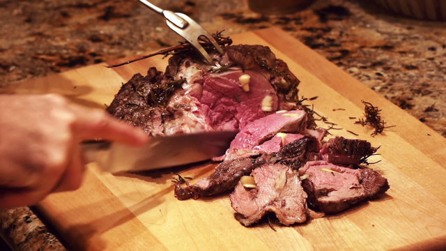 Leg Of Lamb Being Carved In Pieces Boneless With Rosemary.