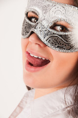 Beautiful young woman in gray carnival mask