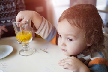 A little boy tries buckthorn tea.