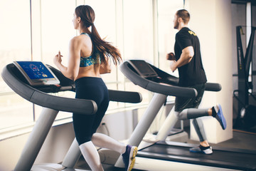 Fototapeta na wymiar Couple running on treadmill