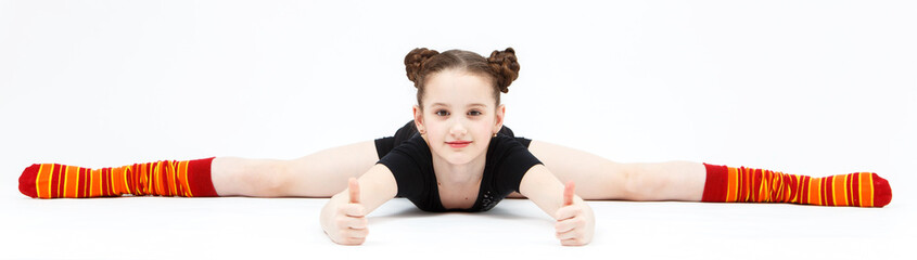 Little girl in black dress doing gymnastic split on white backgr