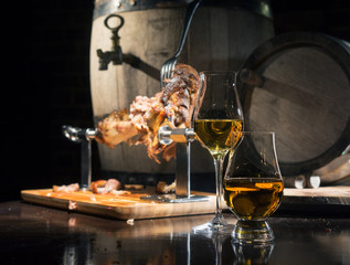 whiskey, cognac, calvados with boiled pork knuckle on the background of oak barrels - obrazy, fototapety, plakaty