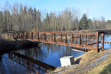 Metal pedestrian bridge across the river Oredezh