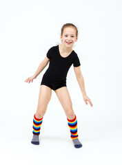 Slim teen girl doing gymnastics dance in jumping on white