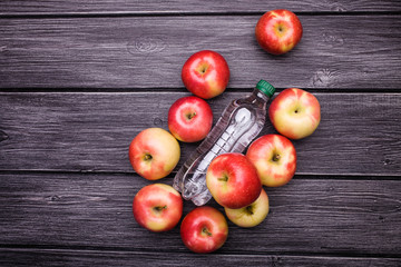 Apples around bottle