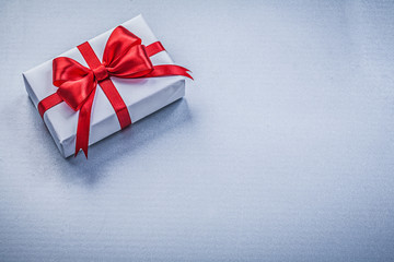 Wrapped present red ribbon on blue background holidays concept