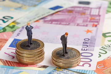 Miniature businessmen on money