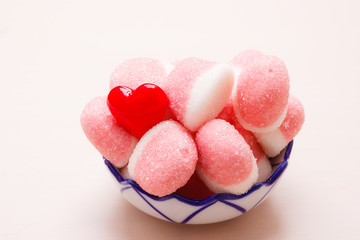Pink jellies or marshmallows with sugar in bowl