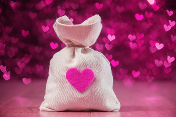 Sack with heart symbol against abstract Valentines day backgroun