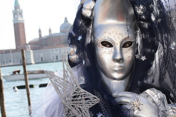 Obraz na płótnie Canvas Carnival mask in Venice posing in San Marco square