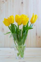 Yellow tulips on a wooden surface
