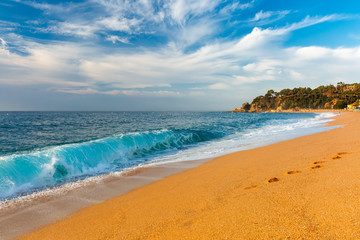 Sea waves and sand main beach at popular holiday resort Lloret de Mar on Costa Brava in the morning , Catalunya, Spain