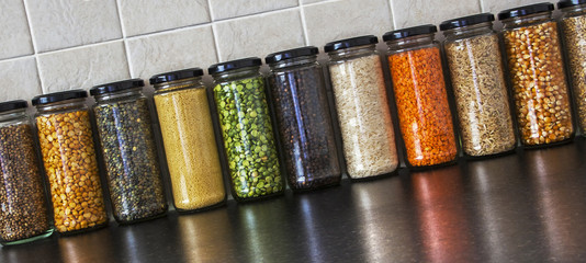 Health Food - variety of seeds and pulses in jars, with reflecti