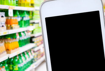 Smart phone over blur product shelves in supermarket background