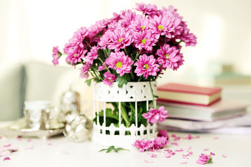 Beautiful flowers in vase on table in room