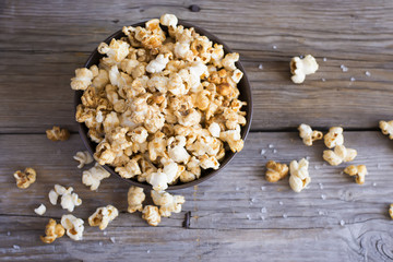 Salt popcorn on the wooden table, selective focus, top view