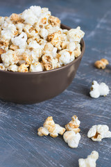 Sweet caramel popcorn in a  bowl on a dark blue background