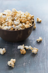 Sweet caramel popcorn in a  bowl on a dark blue background