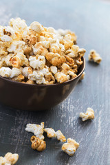 Sweet caramel popcorn in a  bowl on a dark blue background