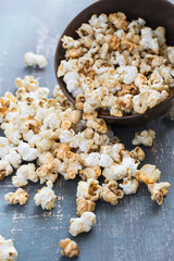 Popcorn with caramel flavor is scattered out of the bowl