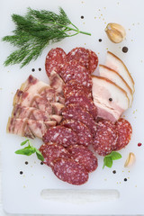 Smoked sausage, bacon and greens on a white background