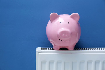 Piggy bank on radiator. Saving  heating in winter