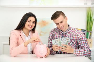 Obraz na płótnie Canvas Happy young couple with dollar banknotes and piggy bank. Money savings concept