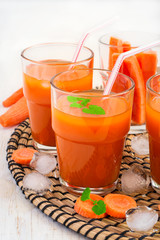 Carrot juice with pulp, ice and mint on a white background