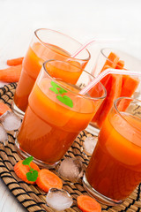 Carrot juice with pulp, ice and mint on a white background