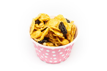 Caramel cornflake with currant in pink paper cup on white background